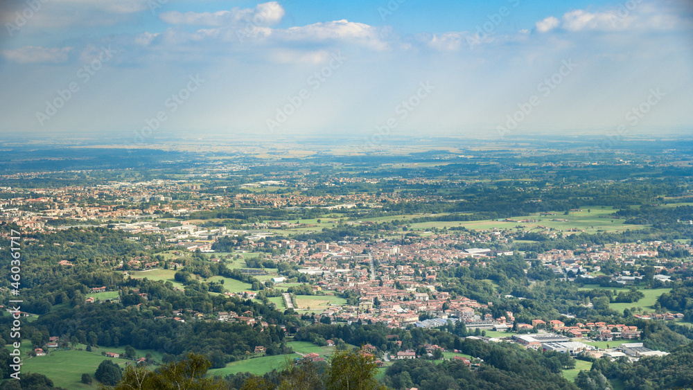 Panoramic view of the Po Valley in the province of Biella and Vercelli. Natural and city panorama on a sunny summer day in northern Italy. City, crops and rice fields in the background. Landscape.