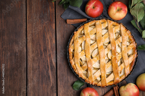 Delicious traditional apple pie on wooden table, flat lay. Space for text