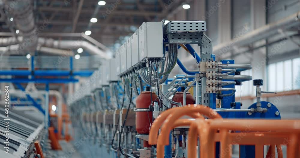 Inside a new modern plant, in a production workshop with technological lines, pipelines, valves, electrics, and other equipment in the infrastructure of a just built wood processing complex Inside a new modern plant, in a production workshop with technological lines, pipelines, valves, electrics, and other equipment in the infrastructure of a just built wood processing complex
