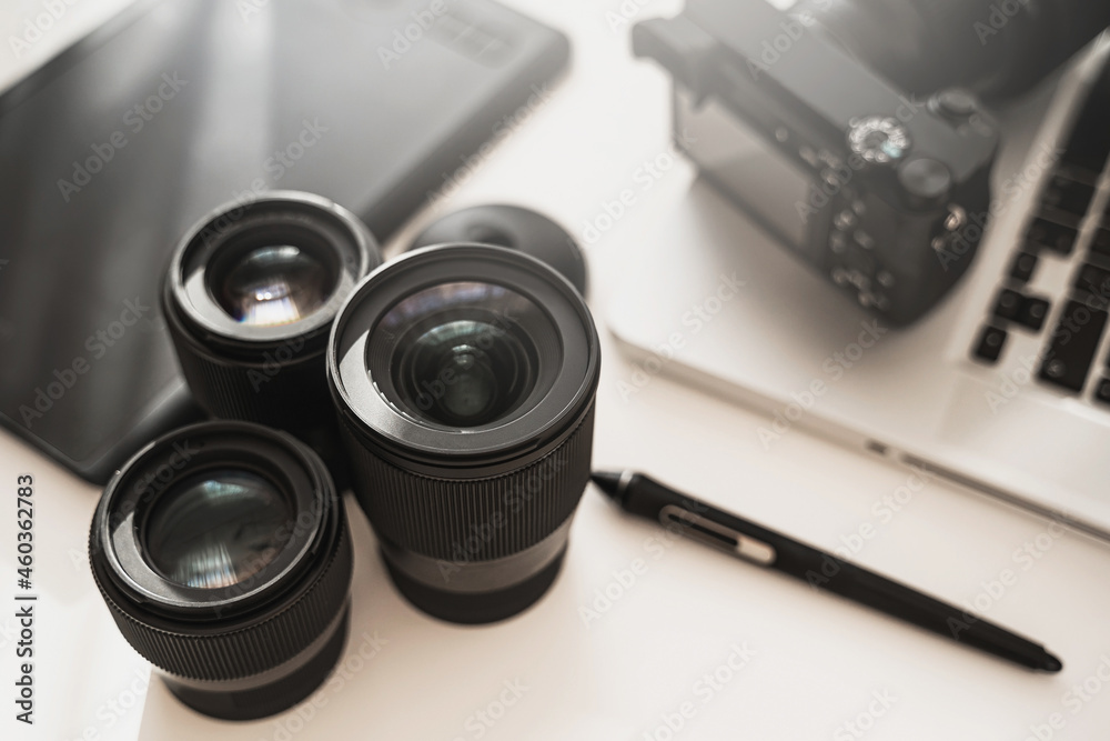 Workplace with a modern equipment for photography. Mirrorless camera and prime lenses.