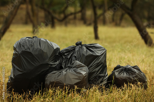 Trash bags full of garbage on grass outdoors