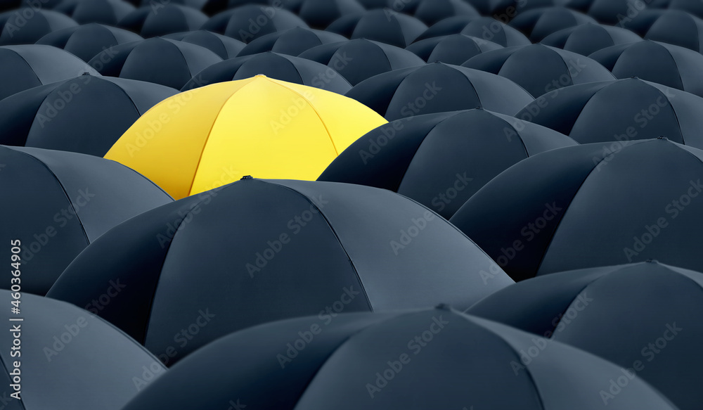 Fototapeta premium Yellow umbrella standing out of other ones