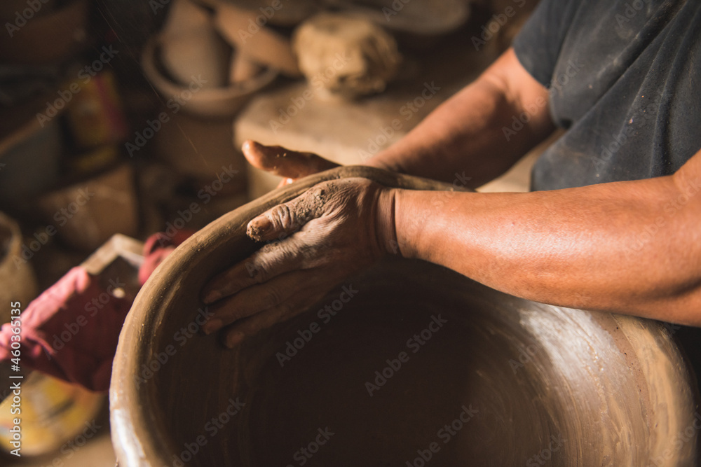 Manufacturer of handmade clay pots working in his workshop to create traditional Mexican kitchen utensils, such as saucepans, casseroles, vases.