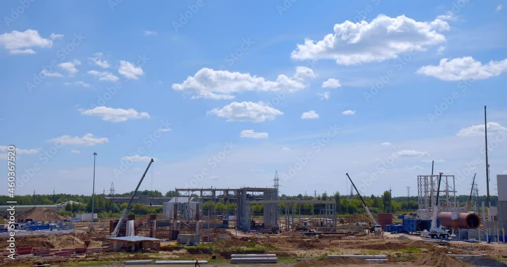 At construction site where a new, modern plant is being built, a lot of equipment works - cranes, tractors, excavators, trucks, hoists, as well as teams of workers. Accelerated shooting, time-lapse At construction site where a new, modern plant is being built, a lot of equipment works - cranes, tractors, excavators, trucks, hoists, as well as teams of workers. Accelerated shooting, time-lapse