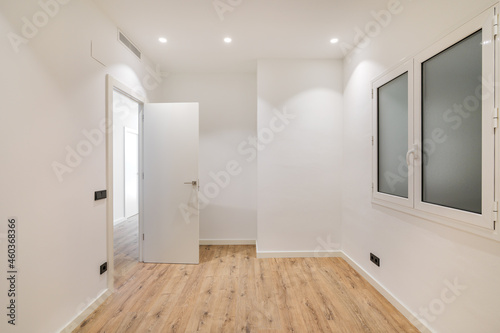 Empty room with window and hardwood floor after renovation. Modern style new interior.