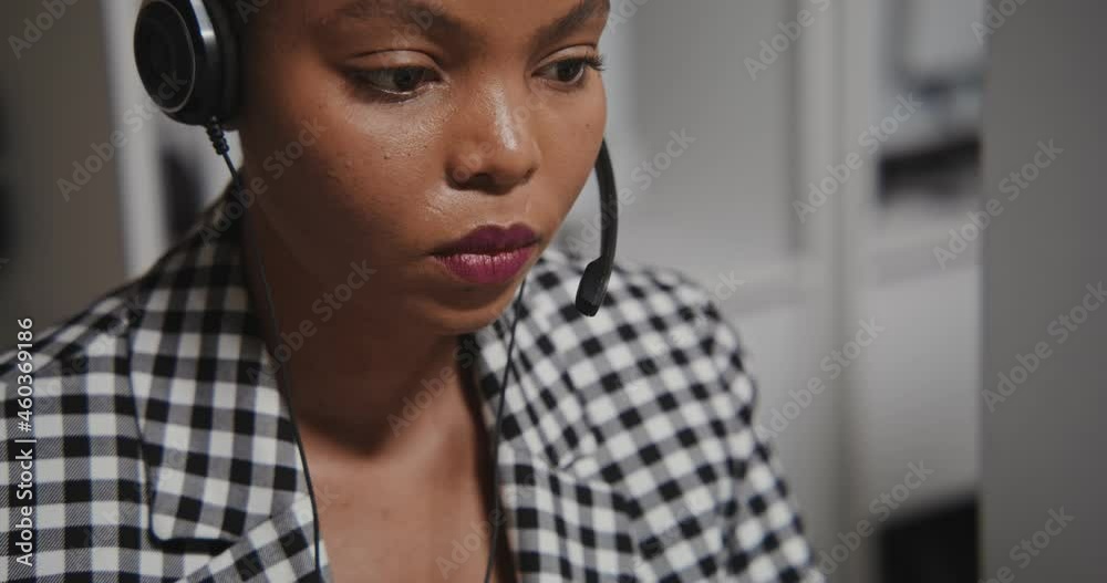 Call center worker african american woman in headphones communicates with client