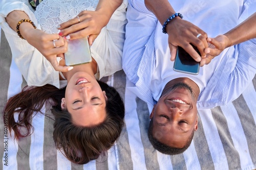 Top view smiling young couple looking at smartphone screens