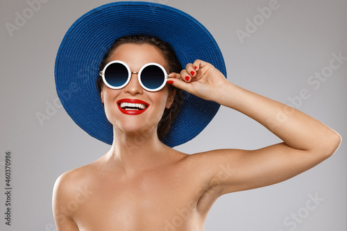 Beautiful woman wearing blue hat and sunglasses is ready for vacation