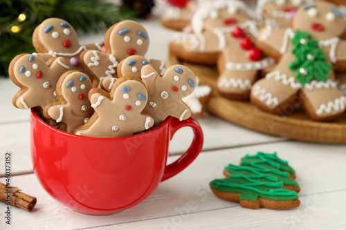 Delicious homemade Christmas cookies in cup on white wooden table. Space for text