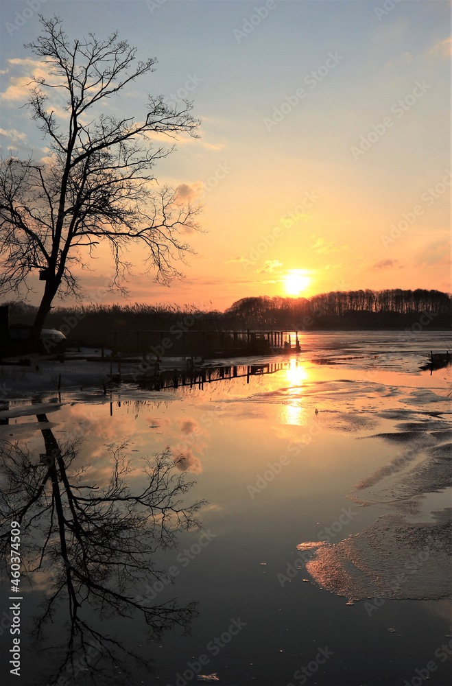 Obraz premium half frozen lake at sunset in winter