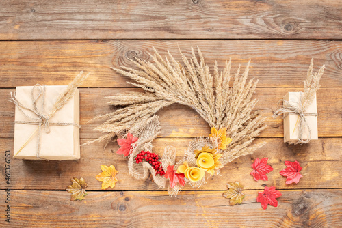 Dried floral wreath, autumn rustic wreath with dry grass, wildflowers on rustic wooden table. Floral autumn door wreath from natural materials. Fall flower decoration workshop. Top view