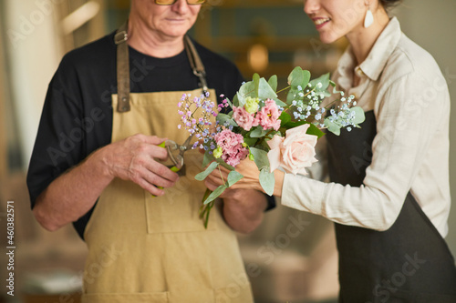 Cropped shot of two florists arraigning flower compositions in cozy workshop  copy space