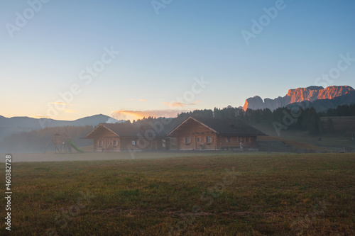 Alpe di Siusi (Seiser Alm) alpine meadow with beautiful sunrise in the background with the Sassolungo and Langkofel mountains visible near the town of Ortisei in the province of South Tyrol