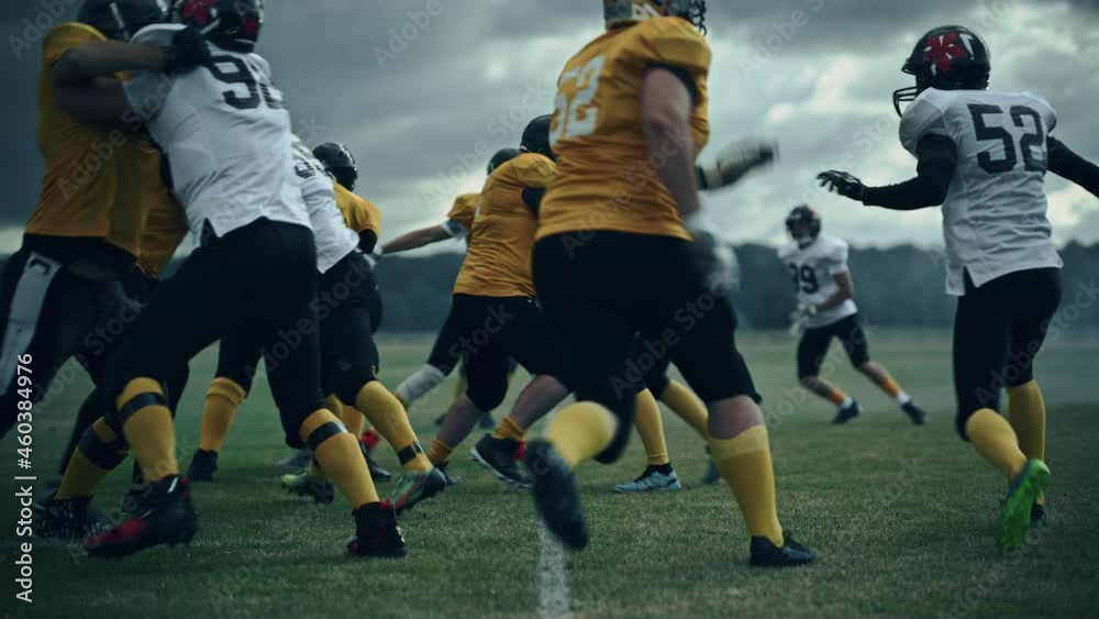 American Football Championship Start Teams Ready: Professional Players, Aggressive Face-off, Start Pushing, Tackling. Competition Full of Brutal Energy, Power. Cinematic Slow Motion, Dramatic Light American Football Championship Start Teams Ready: Professional Players, Aggressive Face-off, Start Pushing, Tackling. Competition Full of Brutal Energy, Power. Cinematic Slow Motion, Dramatic Light