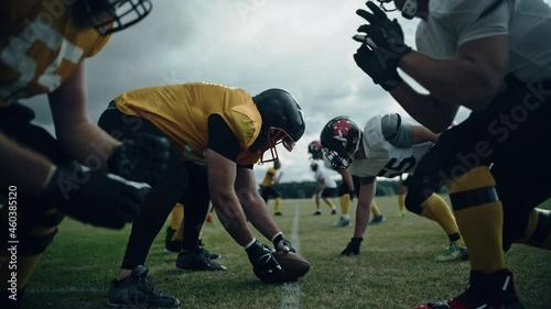 American Football Teams Start Game: Professional Players, Aggressive Face-off, Tackle, Pass, Fight for Ball and Score. Competition Full of Brutal Energy, Power, Skill. Cinematic Handheld Shot photo