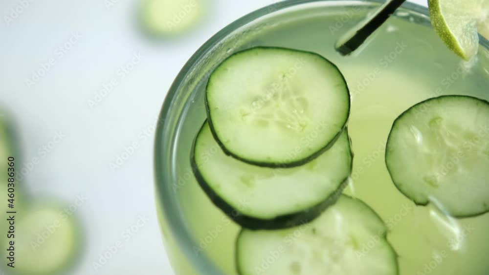 Refreshing cucumber and lime drink on white surface