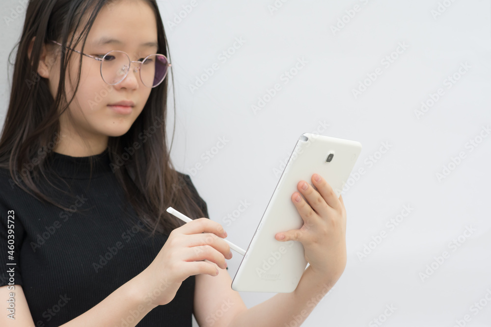 Girl hand holding white digital tablet whiles holding a pen in the other hand. Girl hand holding white digital tablet whiles holding a pen in the other hand.
