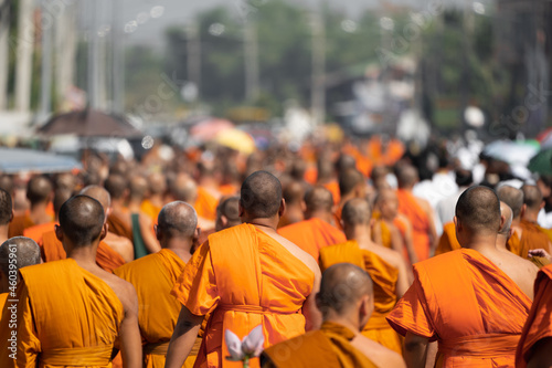 a group of monk on pilgrimage walk on the street at noon time, Thailand.