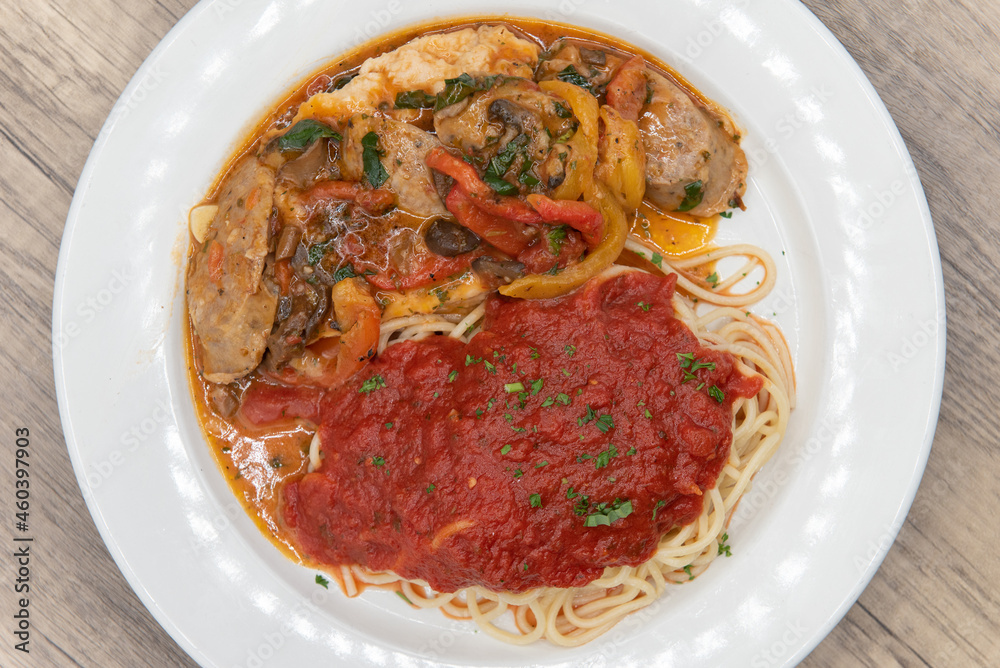 Overhead view of double chicken breast served with spaghetti with marinara sauce as pollo campagnola Overhead view of double chicken breast served with spaghetti with marinara sauce as pollo campagnola