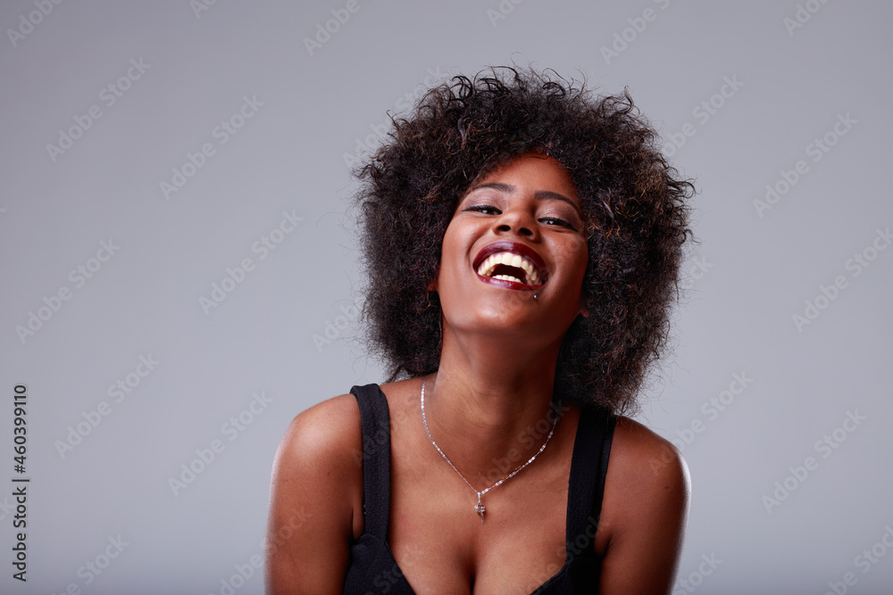Happy fun loving young Black woman laughing at camera Happy fun loving young Black woman laughing at camera