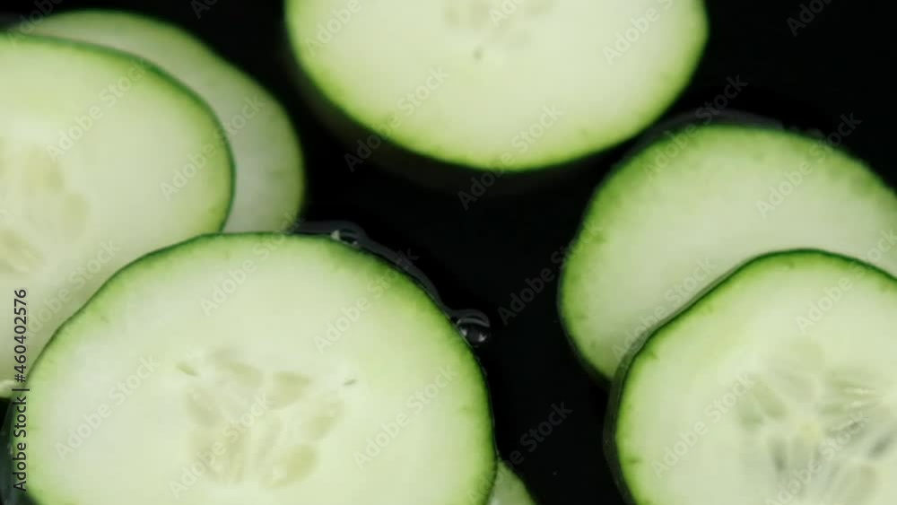 Close-up of group of fresh cucumber slices floating in liquid Close-up of group of fresh cucumber slices floating in liquid