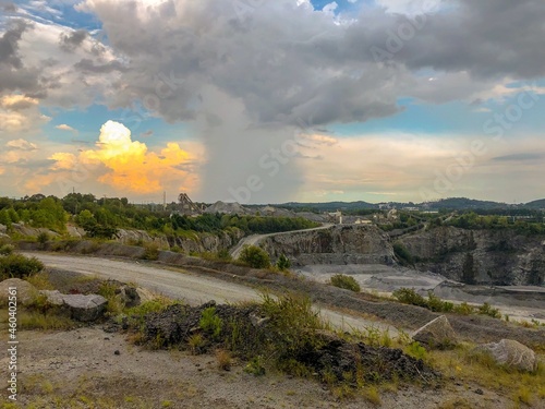 Rain and clouds in the sky overlooking a rock quarry. 
