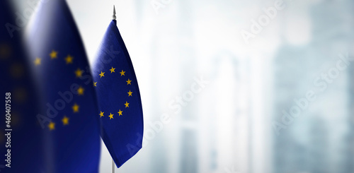 Small flags of European Union on a blurry background of the city
