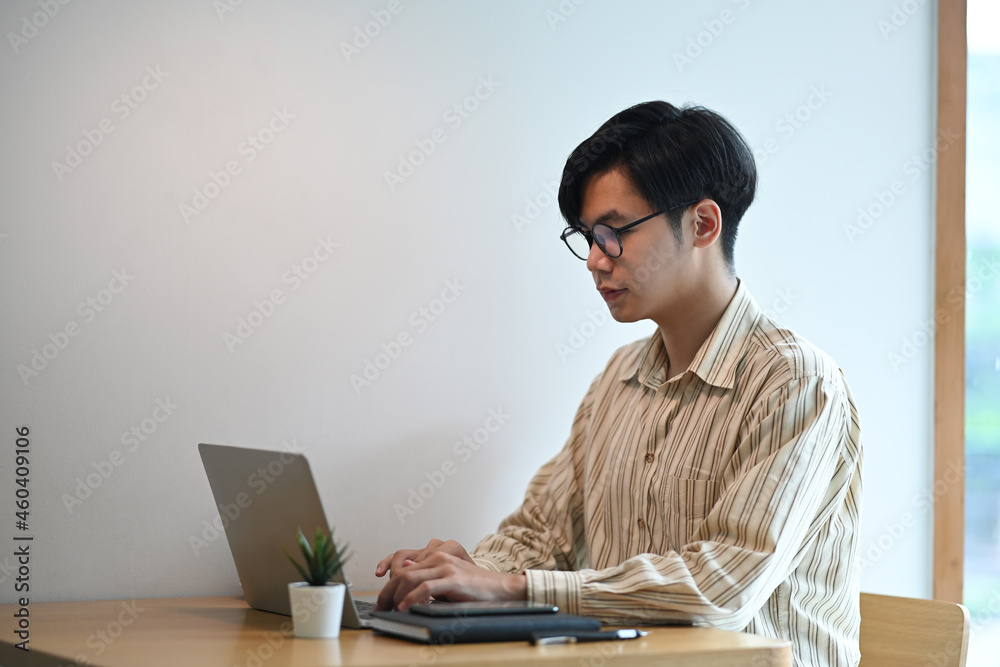 Young man freelancer working online with laptop computer.