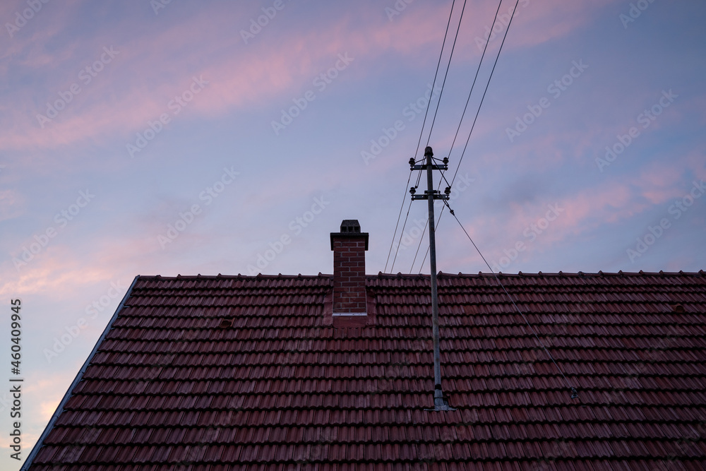 Blue evening sky with pink clouds over the roof of the house Blue evening sky with pink clouds over the roof of the house