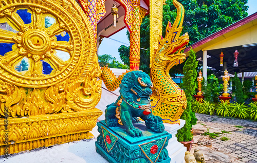 The Wheel of Dharma, Foo Dog (Chinese Imperial Guardian Lion) and Naga serpent, Wat Thong Satja Temple, Lamphun, Thailand photo