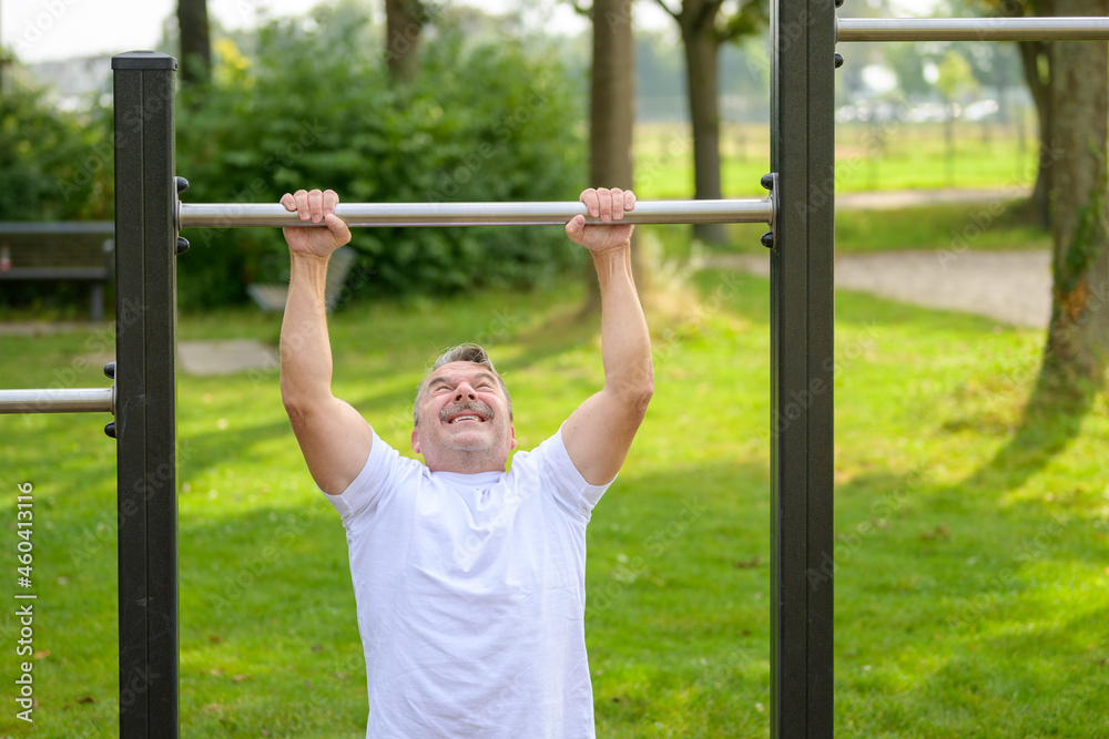 Senior man straining to pull himself up by the arms Senior man straining to pull himself up by the arms