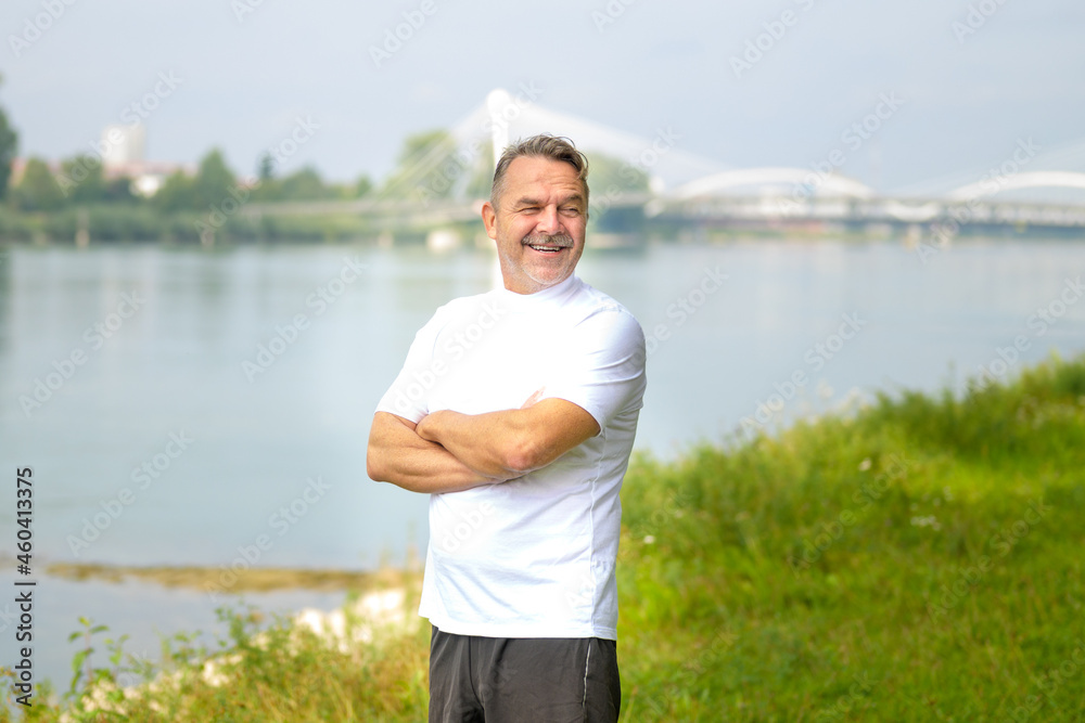 Senior man standing looking aside with a beaming smile Senior man standing looking aside with a beaming smile