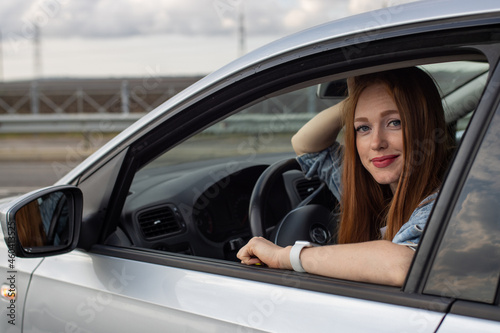 beautiful redhead girl driving a car