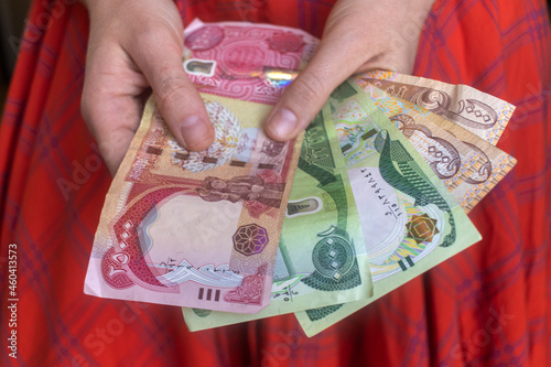 Woman holding various Iraqi dinar banknotes. photo