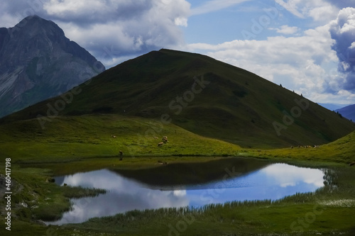 gorgeous mountain lake with reflections from the blue sky with many clouds close up