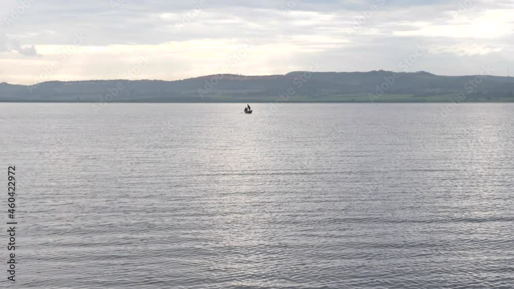 A small fishing canoe out in the distance on Lake Victoria in the early morning. A small fishing canoe out in the distance on Lake Victoria in the early morning.