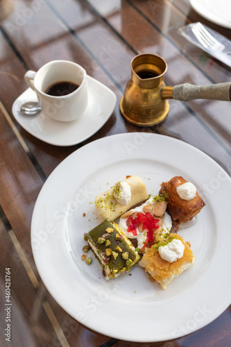 Foto Tripoli, Lebanon, January 19, 2019, various traditional oriental sweets on a plate, Lebanese cuisine, a cup of coffee and a coffee turka (coffee pot)