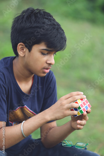 Foto Indian boy try to complete the rubik's cube - technical and business solving pro