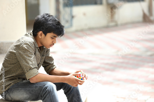 Foto Indian boy try to complete the cube - technical and business solving problem and