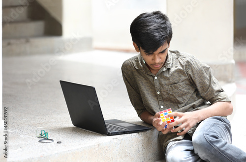 Foto Indian boy try to complete the rubik's cube - technical and business solving pro
