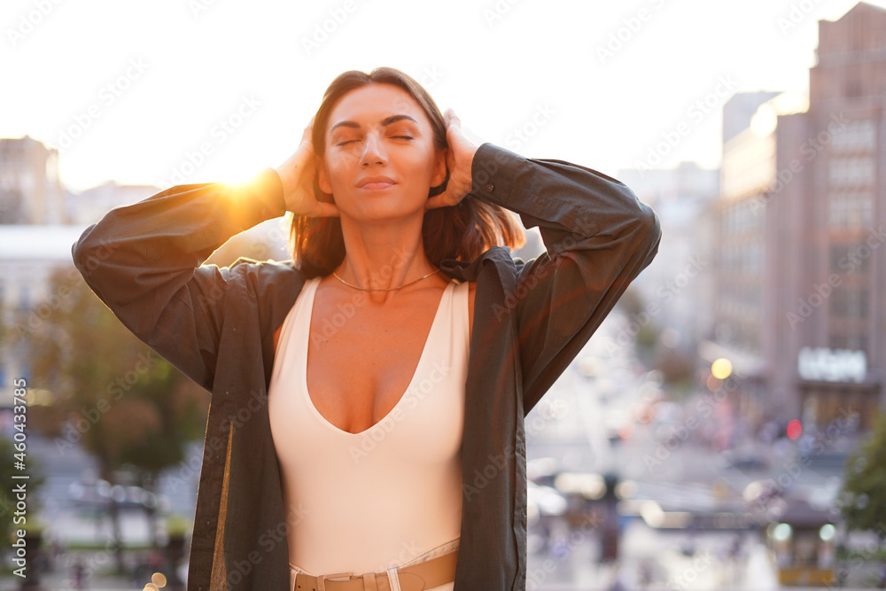 Woman at sunset with amazing city view, enjoying warm days, freedom, positive vibes Woman at sunset with amazing city view, enjoying warm days, freedom, positive vibes