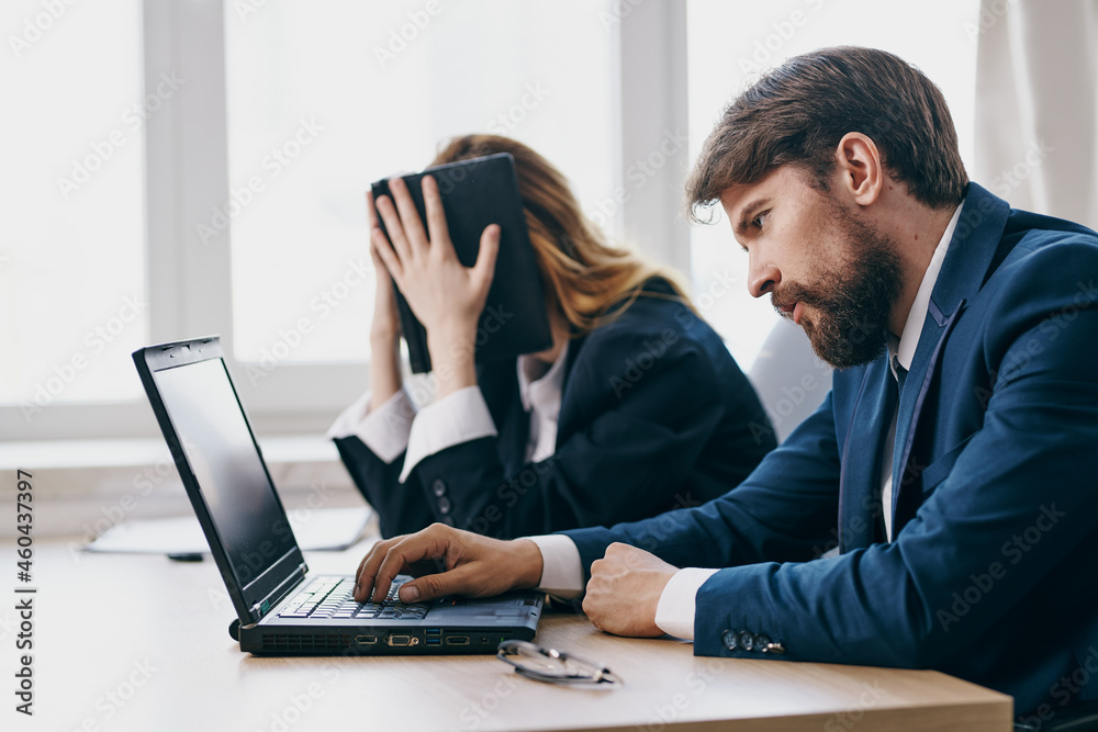 colleagues in the office in front of a laptop career work officials colleagues in the office in front of a laptop career work officials
