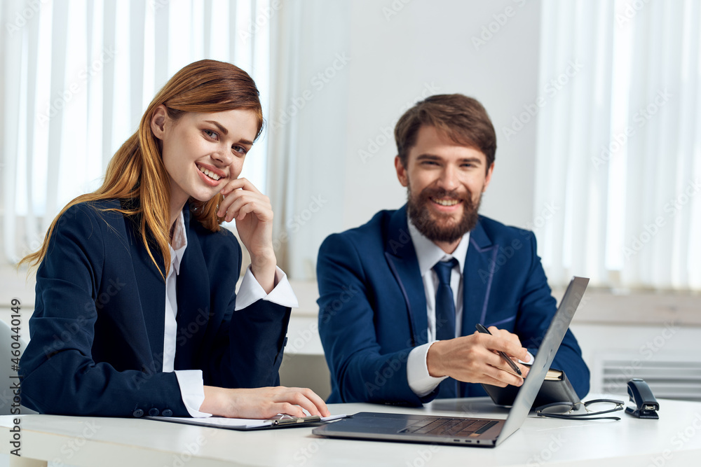 man and woman managers talking at the table in front of laptop team technology man and woman managers talking at the table in front of laptop team technology