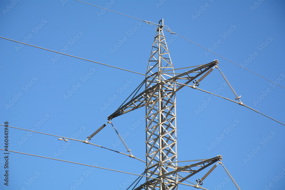 Electricity pylon in a field with blue sky. A transmission tower. High voltage tower Electricity pylon in a field with blue sky. A transmission tower. High voltage tower