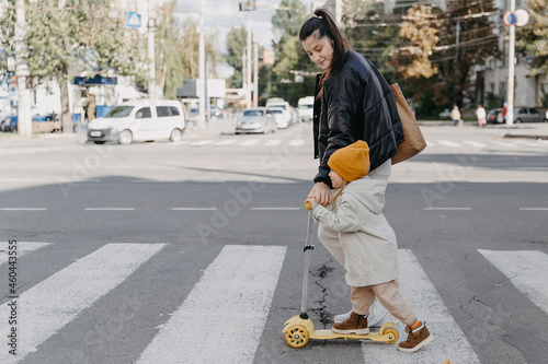 happy cute little kid girl cross the road with mother