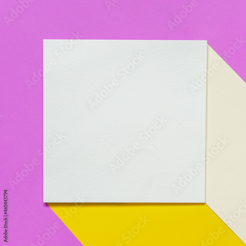 Identity mockup card concept with a blank white brochure on two colour of yellow  paper against a pastel purple paper background.