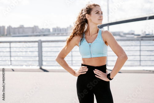 Sports and clothing for women. Fitness break in the city. Cardio training for weight loss. The athlete leads a healthy lifestyle. The trainer counts the pulse on a smart watch.