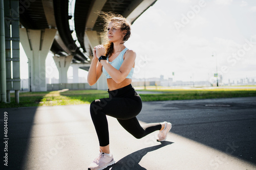 Cardio training for weight loss. Sports clothing for women. Fitness in the city. A professional trainer does warm-up exercises before training. The athlete leads a healthy lifestyle.
