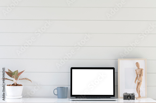 Creative workspace with laptop computer and decoration object on white table.