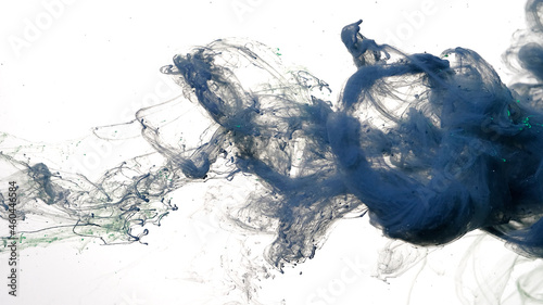 Gray-blue watercolor ink in water on a white background. Gray-blue cloud of ink on a white background. Abstract background. Drops of dark blue ink in water.